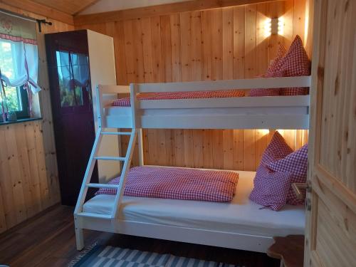 a bedroom with two bunk beds in a cabin at Vogelsberger Zirbenstüberl in Grebenhain