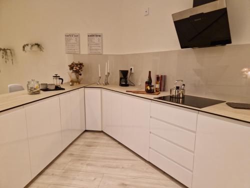 a kitchen with white cabinets and a sink at Lorans in Perstorp