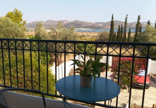a blue table on a balcony with a potted plant at Marco Polo's Mooring Cozy Navy House in Anavissos