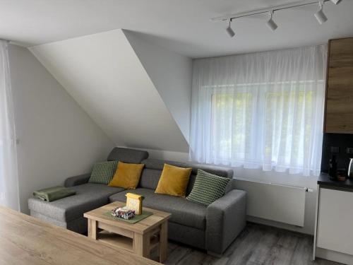 een woonkamer met een bank en een tafel bij Apartmán - Dolní Morava - "Sedmička" pro 2 až 6 osob in Dolní Morava