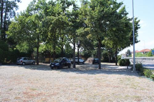 a group of cars parked in a parking lot with trees at Praga in Serravalle Scrivia