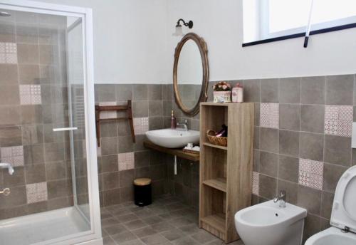 a bathroom with a sink and a toilet and a mirror at Praga in Serravalle Scrivia