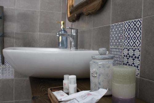 un bagno con lavandino e bancone con candela di Praga a Serravalle Scrivia