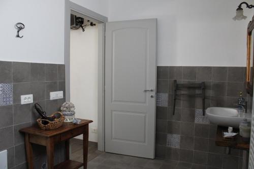 a bathroom with a white door and a sink at Praga in Serravalle Scrivia