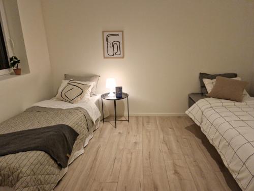 a bedroom with two beds and a table with a lamp at Lorans in Perstorp
