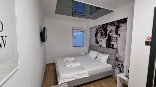 a white bedroom with a bed with white sheets at Relax House NS in Novi Sad