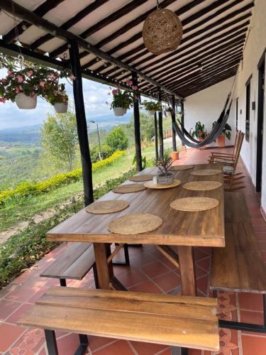 a long wooden table on a patio with benches at Casa Luna Hotel Campestre & Spa in San Gil