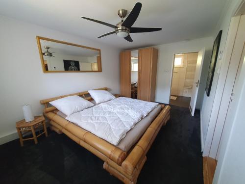 a bedroom with a bed with a ceiling fan at Caron in Böhl