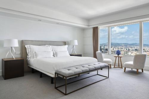 a white bedroom with a large bed and a window at Hotel Arts Barcelona in Barcelona