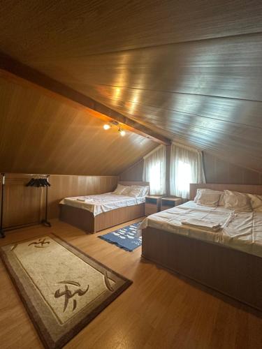 a bedroom with two beds in a room with a ceiling at Sunset By The Lake Ponton Bicaz in Bicaz