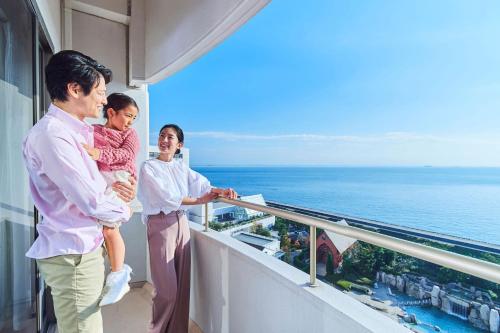 three people standing on a balcony looking at the ocean at Sheraton Grande Tokyo Bay Hotel in Urayasu