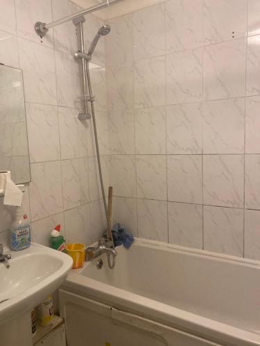 y baño con bañera, lavamanos y bañera. en Quiet flat with a private spacious room, en Birmingham