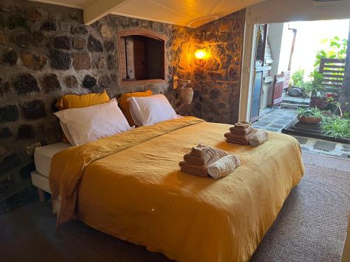 1 dormitorio con 1 cama grande y toallas. en La Case Chouchou, en Étang-Salé les Bains