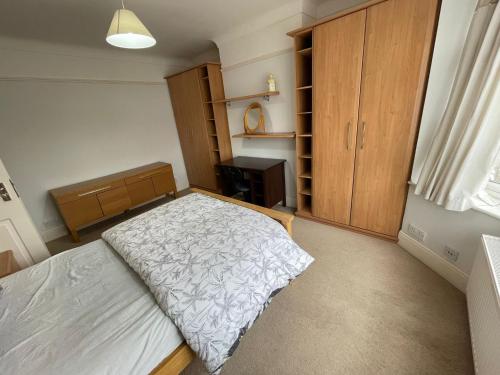 1 dormitorio con 1 cama y armario de madera en Nharakat Mansion, en Southampton