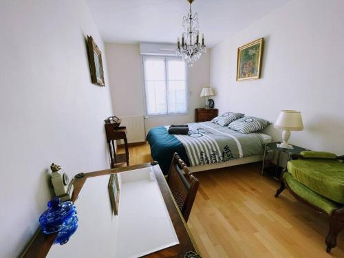 a bedroom with a bed and a table and a couch at Appart familial, proche Disney, Paris in Bussy-Saint-Georges