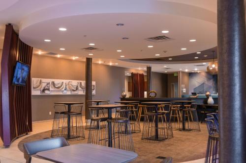 ルイスビルにあるSpringHill Suites by Marriott Dallas Lewisvilleのスツールとテーブルのあるバー