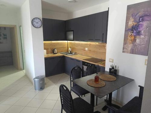 a kitchen with a table and chairs and a clock at Beach apartments Liljana - Durres in Durrës
