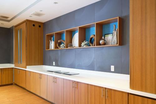 cocina con armarios de madera y encimera blanca en SpringHill Suites by Marriott Dallas Lewisville, en Lewisville