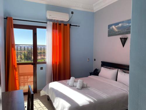 1 dormitorio con cama blanca y ventana en Hotel Rayyan l 'Escale, en Ouarzazate