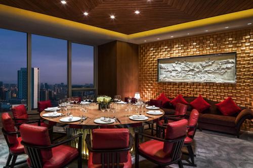 a dining room with a large table and red chairs at The St. Regis Chengdu in Chengdu