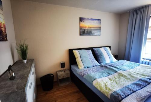 um quarto com uma cama com almofadas azuis em Ferienwohnung im Starenweg em Blankenburg