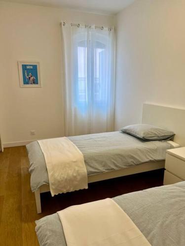 une chambre avec deux lits et une fenêtre dans l'établissement T4 atypique plein centre ville classé 3 étoiles, à Sète