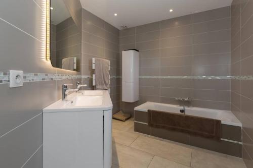 une salle de bain avec un lavabo et une baignoire dans l'établissement Villa climatisée piscine billard ping-pong, à Saint-Maximin