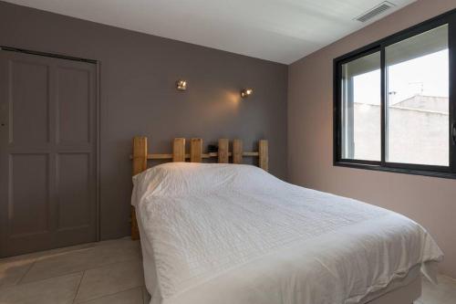 une chambre avec un lit blanc et une fenêtre dans l'établissement Villa climatisée piscine billard ping-pong, à Saint-Maximin