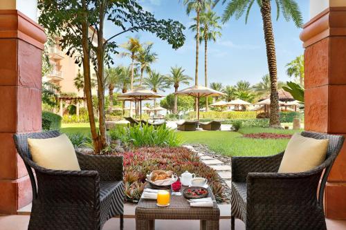 um pátio com cadeiras e uma mesa com comida em The Ritz-Carlton, Dubai em Dubai