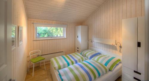 a small bedroom with a bed and a window at Timmenhus - Ferienhäuser am Feldrand in Timmendorfer Strand