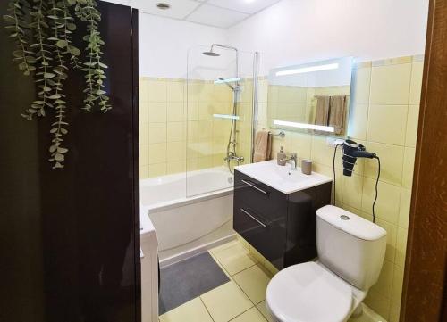 a bathroom with a white toilet and a sink at Stylish apartment with parking & spacious balcony in Rīga