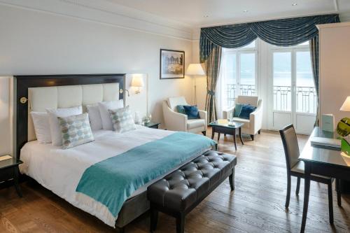 Cette chambre comprend un lit, un bureau et des chaises. dans l'établissement Grand Hotel Suisse Majestic, Autograph Collection, à Montreux