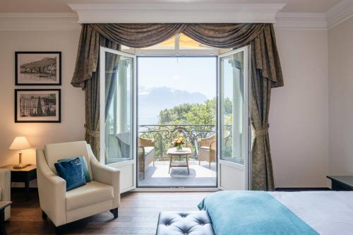 a bedroom with a king sized bed and a large window at Grand Hotel Suisse Majestic, Autograph Collection in Montreux