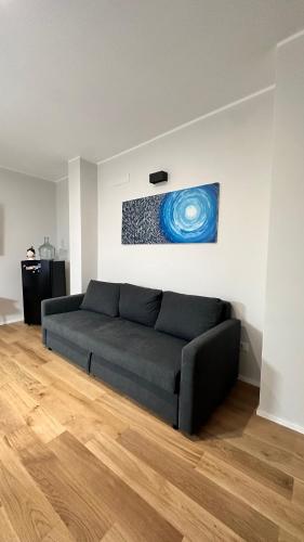 a couch in a living room with a painting on the wall at Centro Storico Caruggi 2min Acquario Pellicceria Superior Loft Palazzo Rolli in Genova
