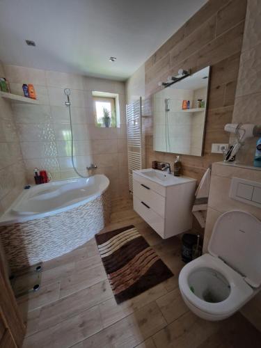 a bathroom with a tub and a toilet and a sink at Ubytovanie HANKA in Svidník
