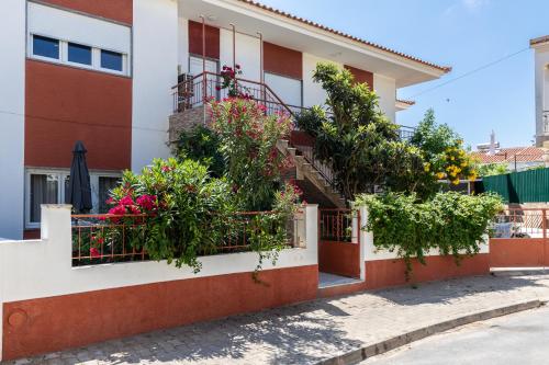 a building with flowers and plants on the balconies at Porta Nova Guesthouse by R-Tex in Tavira