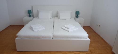 a white bed with two white pillows on it at Apartma pri Boru in Ptuj