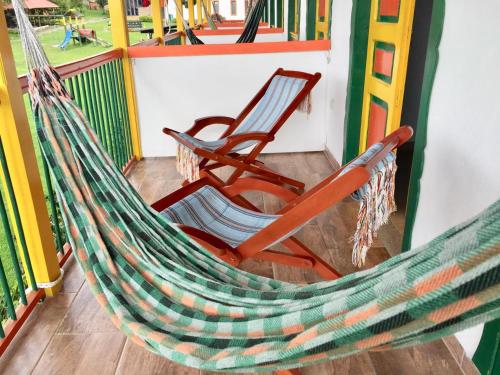 a hammock and a chair on a ride at Mamatina Hotel in Santa Rosa de Cabal