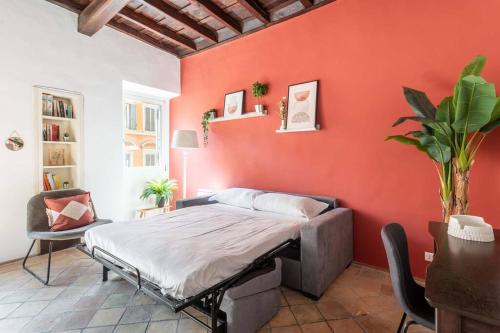 um quarto com uma cama e uma parede vermelha em Maison Leonardo al Colosseo em Roma