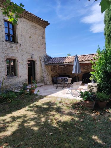 an outdoor patio with a table and an umbrella at Saint Laurent in Portes-en-Valdaine