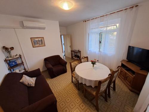 a living room with a table and a tv at Kuća za odmor "Dida Pere" in Zaton