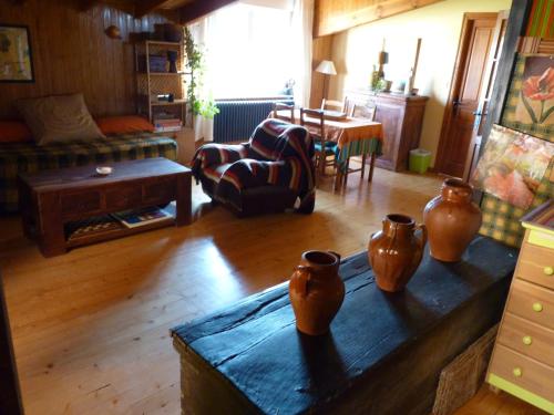 a living room with a table with vases on it at Hotel Rural La Rosa de los Tiempos in Carneros