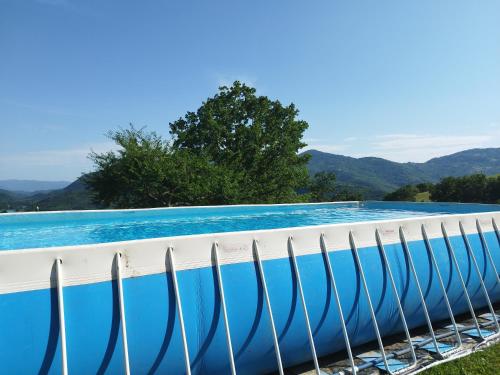 una piscina de agua azul y montañas de fondo en Agriturismo le cascine, en Castel di Tora