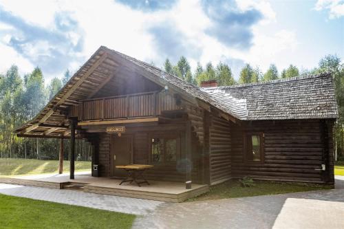 a log cabin with a table in front of it at Holiday home Migliņas in Kaugurmuiza