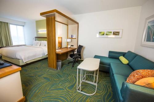 SpringHill Suites Lumberton في لومبيرتون: غرفة في الفندق مع أريكة وسرير