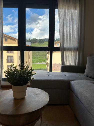 a living room with a couch and a table and a large window at Precioso Piso en La Molina in La Molina