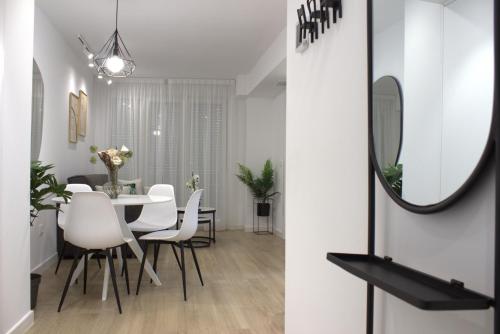 jadalnia ze stołem, krzesłami i lustrem w obiekcie Apartamento Granada-Hipercor w Grenadzie