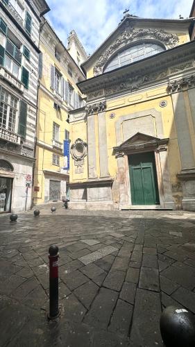 a large building with a green door on a street at Centro Storico Caruggi 2min Acquario Pellicceria Superior Loft Palazzo Rolli in Genova