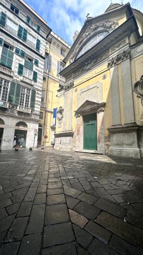 a large building with a green door on a street at Centro Storico Caruggi 2min Acquario Pellicceria Superior Loft Palazzo Rolli in Genova