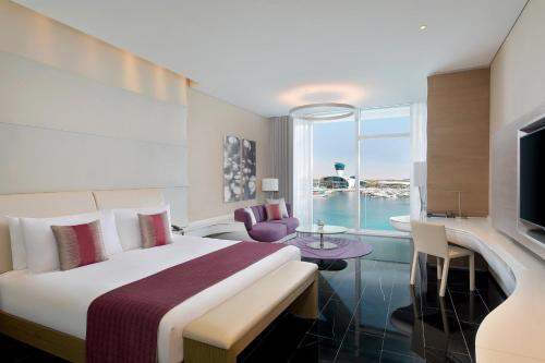 a hotel room with a large bed and a tv at W Abu Dhabi - Yas Island in Abu Dhabi